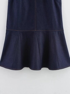 Detailed view of dark blue denim dress hem with orange stitching and ruffled texture