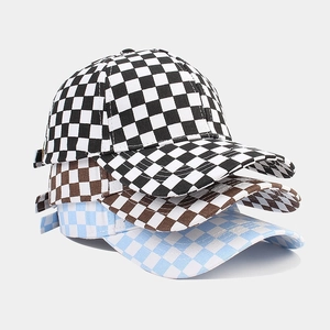 Stacked canvas baseball caps featuring checkerboard patterns in black, brown, and blue colors