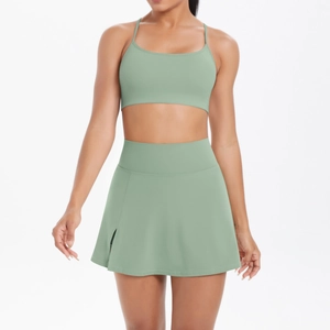Détail d'un ensemble de yoga vert sauge avec brassière de sport et jupe de tennis fendue
