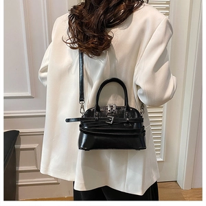 Detailed back view of a black glossy crossbody bag with dual handles and silver hardware