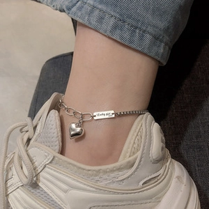 Dettaglio della cavigliera in argento 925 con pendente a cuore e targhetta Lucky Girl