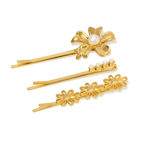 Détail de trois pinces à cheveux dorées 18 carats avec fleurs en nacre et perles