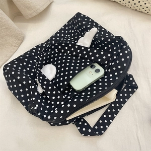 Spacious black polka dot travel pouch with plush wings showing interior storage capacity
