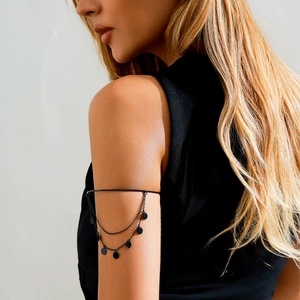 Detail of gothic black arm ring with minimalist layered chain fringe on model