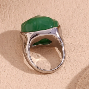 Macro shot showing silver-tone stainless steel ring base with irregular green stone inlay