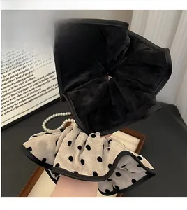 Detail of oversized polka dot and black velvet scrunchies set with soft fabric texture