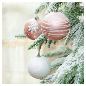 Detailed view of pink snowflake and white frosted ornaments hanging on snowy Christmas tree