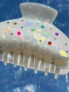 Dettaglio di una pinza per capelli a farfalla perlata con strass colorati brillanti