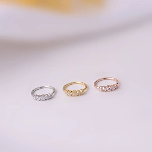 Detailed macro view of silver gold and rose gold nose rings with sparkling zircons
