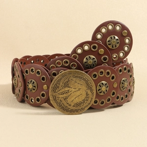 Detail of brown leather rivet belt with circular plates and decorative metal floral eyelets