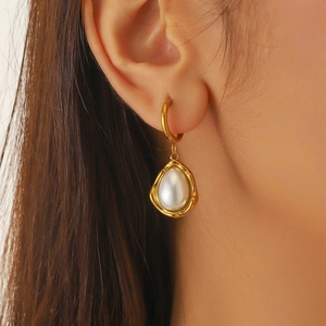 French vintage gold-plated teardrop pearl earrings on model showing elegant texture