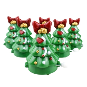 Macro detail of wind-up walking Christmas tree toys with red bows and colorful ornaments