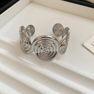 Close-up of a silver spiral vortex open cuff bracelet with metallic pleated textures