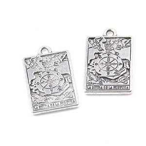 Macro detail of antique silver Wheel of Fortune tarot charms for jewelry making