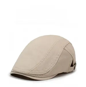 Detail view of beige cotton flat cap showing side adjustable strap with metal buckle