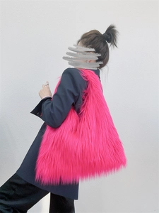 Close-up of fluffy pink faux fur tote bag with long plush texture worn by a model