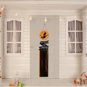 Detail of Halloween door hanger featuring black and orange tassels with The Witch is Coming sign
