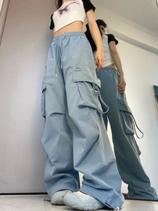 Detail view of blue high-waisted cargo pants with side pockets and long wide-leg fit