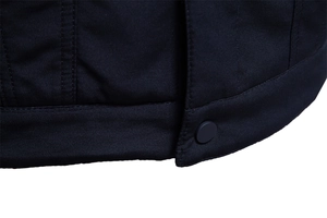 Dettaglio della trama in twill blu scuro e bottone a pressione sull'orlo della giacca