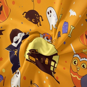 Detailed macro view of soft orange Halloween tapestry fabric with cartoon ghosts and bats