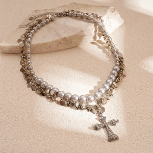 Double-layered necklace with pearl chain, heart charms and rhinestone cross pendant