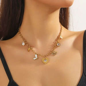 Gold layered necklace with pearl and heart pendants on a female model's collarbone