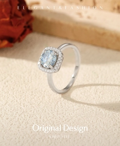 Macro shot of silver ring with square light blue moissanite gemstone and halo diamonds