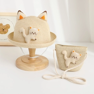 Vue détaillée du chapeau de paille enfant et sac chat avec jolies peluches décoratives