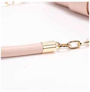 Detailed shot of pink leather handle with polished gold metal chain link on handbag