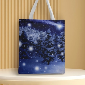 Close-up of canvas handbag with blue winter forest scene and white handles on pedestal