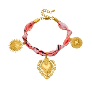 Bracelet foulard en soie rose avec breloques cœur et soleil dorés sur fond blanc