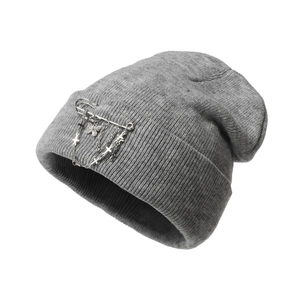 Close-up of grey knitted beanie with punk metal safety pins and butterfly chain charms