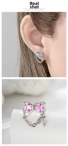 Detail of bow stud earrings with heart zircon and dangling star chain tassel