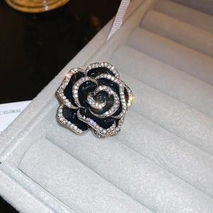 Vue macro d'une broche rose noire avec cristaux brillants sur pétales vintage