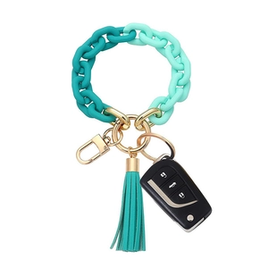 Detailed close-up of a gradient green acrylic bracelet keychain with a green leather tassel
