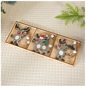 Three assorted wooden reindeer ornaments with white beads on a soft waffle fabric background