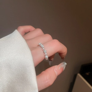 Close-up of elegant silver band ring with alternating white pearls and sparkling zircons