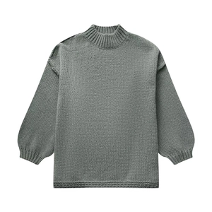 Detail of grey chunky knit sweater featuring crew neck and lantern sleeve texture