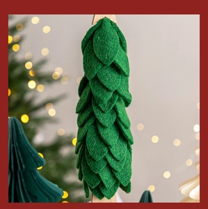 Close-up of green felt Christmas tree decor with textured layers and warm bokeh lights