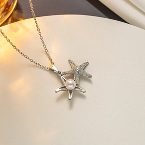 Macro detail of silver starfish necklace featuring sparkling zircon gems and a center pearl