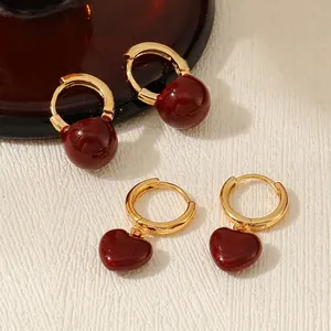 Elegant gold-plated hoop earrings set with deep red enamel heart and ball charms