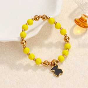 Elastic beaded bracelet with yellow stones and gold metal beads featuring a black bear charm