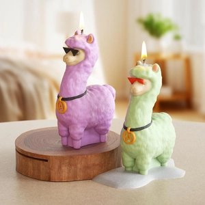 Close-up of lit alpaca shaped candles in purple and green with sunglasses and necklaces