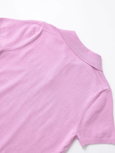 Close-up of pink knit polo shirt featuring refined collar stitching and ribbed cuff details