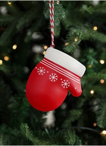 Detailaufnahme vom rot-weißen Weihnachtshandschuh mit Schneeflocken am Weihnachtsbaum