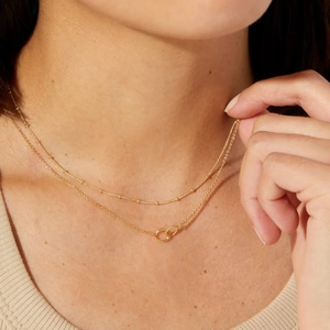 Double-layered gold stainless steel necklace with interlocking rings shown on neck