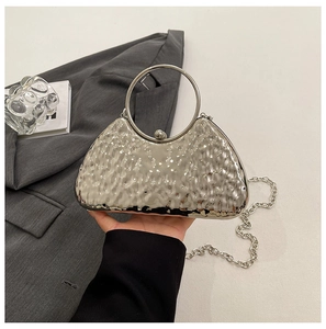 Dettaglio della borsa da sera argento con texture metallo martellato e manico a cerchio