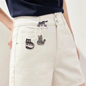 Three cat piano enamel pins pinned on model's clothing for a stylish and creative look