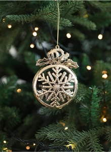 Dettaglio del fiocco di neve dorato appeso all'albero di Natale con calde luci bokeh