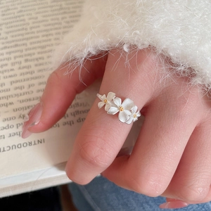Macro shot of silver flower ring with matte texture and golden pistil details
